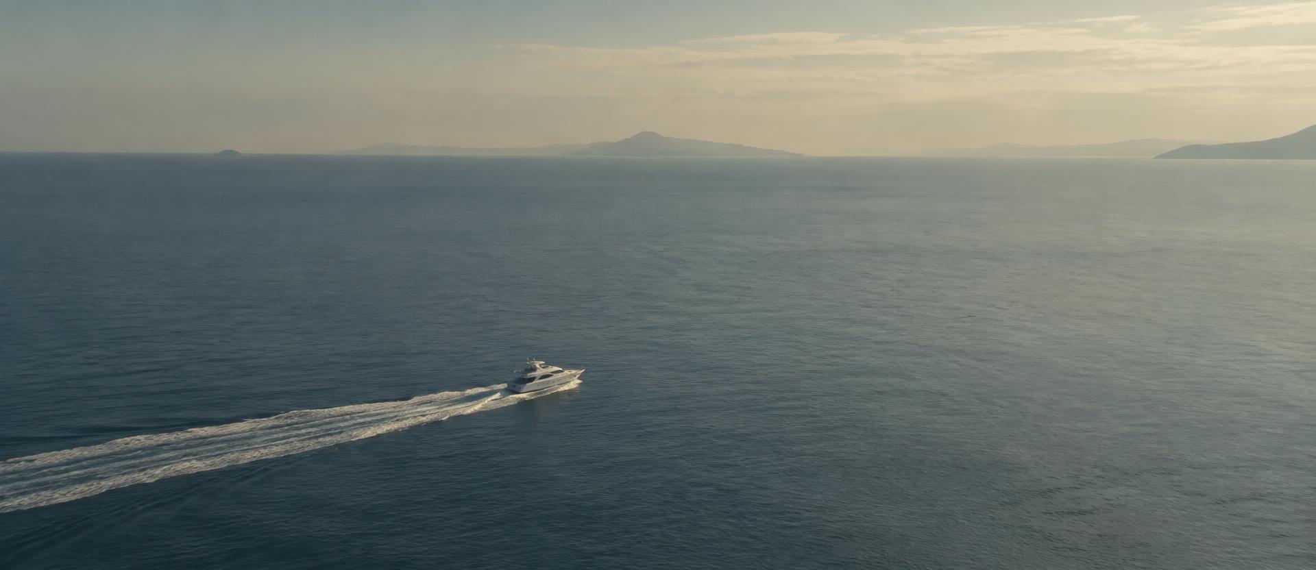 A small white vessel crossing a vast sea, leaving a long wake